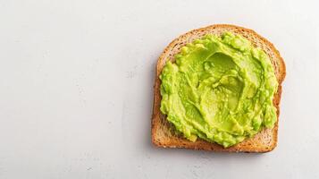 Single Slice of Toast with Fresh Mashed Avocado on White Background Healthy Breakfast Snack Photo