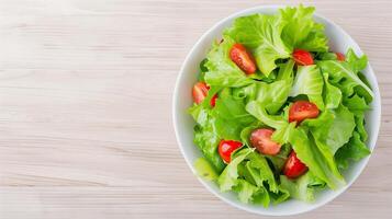 Overhead View of Fresh Garden Salad with Lettuce and Cherry Tomatoes in White Bowl on Light Wooden Background Suitable for Healthy Eating and Vegan Diet Concepts Spring Summer Meal Prep Themes 3 photo