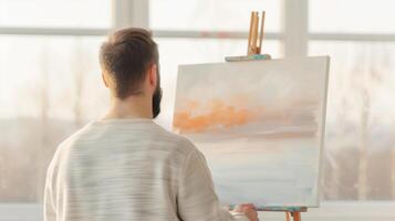 A Thoughtful Artist Painting a Serene Landscape in a Sunlit Studio with Soft Pastel Colors on a Canvas, Concept of Creativity and Artistry in Tranquil Setting photo