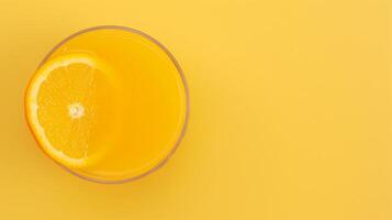 Overhead View of Fresh Orange Juice in a Glass with a Slice on Vibrant Yellow Background Reflecting Bright Citrus Themes and Refreshing Lively Design Elements for Summer or Health-Focused Concepts photo