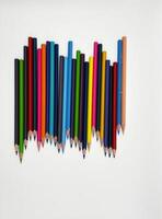 Colorful sharpened pencils are lined up on the table. photo