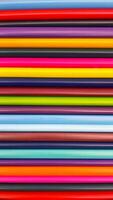 Colorful sharpened pencils are lined up on the table. photo