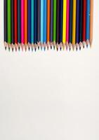 Colorful sharpened pencils are lined up on the table. photo