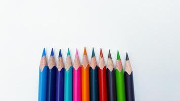 Colorful sharpened pencils are lined up on the table. photo