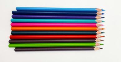 Colorful sharpened pencils are lined up on the table. photo
