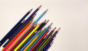 Colorful sharpened pencils are lined up on the table. photo