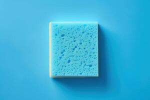 A blue sponge resting on a light blue surface, emphasizing its texture and design photo