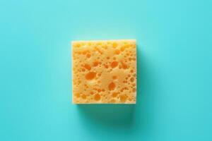 Bright yellow kitchen sponge on a turquoise background photo