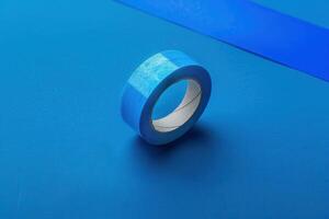 Blue masking tape on a vibrant blue background with additional tape strip photo