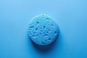 Blue sponge on a light blue background showcasing texture and color contrast photo