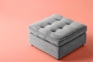 Soft gray ottoman on a peach wall in a modern minimalist room photo