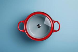 Bright red cooking pot with glass lid on a light blue background photo