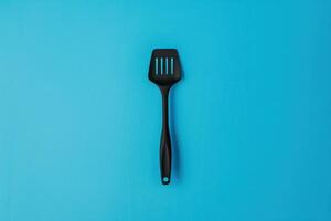Black spatula on a blue background photo