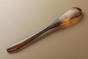 Elegant amber spoon resting on a smooth surface with soft lighting photo