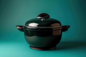 Classic black cooking pot on a turquoise background in a well-lit kitchen setting photo