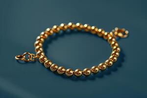 Golden bead bracelet on a blue background, showcasing elegant jewelry design photo