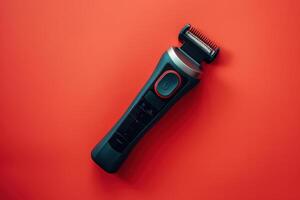 Electric trimmer lying on a bright orange background with buttons and adjustable comb photo