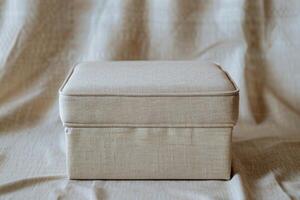 Simple linen storage box placed on a soft fabric background in natural light photo