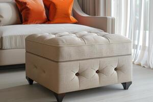 Elegant tufted ottoman in a cozy living room with orange pillows on a sofa photo