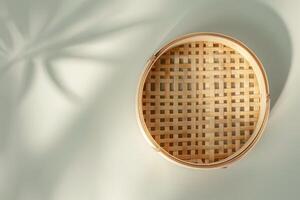 Bamboo steamer basket placed on a light surface with soft shadows in bright daylight photo