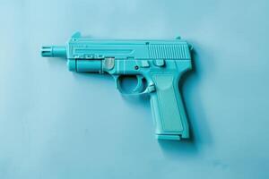 Turquoise toy gun resting on a blue background, showcasing its vibrant color and design photo