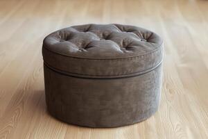 Round tufted ottoman on wooden floor in a bright, modern living room photo