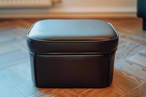 Modern black leather storage ottoman on wooden flooring in a well-lit room photo