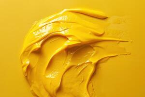 Bright yellow paint smeared on a smooth surface in an abstract design photo