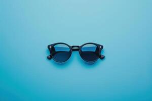 Stylish black sunglasses on a vibrant blue background photo