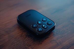 Close-up view of a remote control on a wooden table in soft lighting photo
