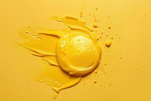 Bright yellow paint splatter on a smooth surface with textured details photo