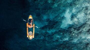 Woman kayaking in ocean on transparent kayak. Drone view with copy space photo