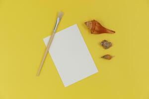 Blank paper mockup with brush and shells photo