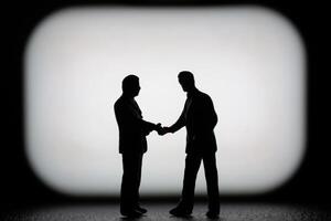 Miniature businessman in a professional agreement, with a blurred background to emphasize the interaction. photo