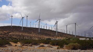 se av vind turbiner alstrande elektricitet. enorm array av gigantisk vind turbiner spridning över de öken- i handflatan fjädrar vind odla, kalifornien video