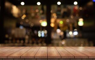 Empty wooden table top with lights bokeh on blur restaurant background photo