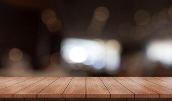 Empty wooden table top with lights bokeh on blur restaurant background photo