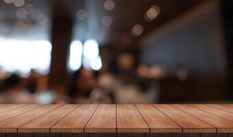 Empty wooden table top with lights bokeh on blur restaurant background photo