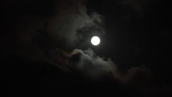 Full moon and partly cloudy sky at night. Moon behind the clouds. Halloween concept 4k . video
