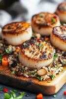 Perfectly seared scallops accompanied by quinoa and colorful vegetables on a wooden platter photo