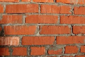 brick macro photo. Brick wall, close-up of red bricks with concrete between the seams. Construction background photo