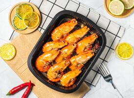 Grilled Shrimp with Lemon slice and fork served in black tray isolated on table top view of taiwan seafood photo