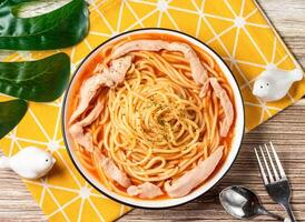 Chicken Pasta Noodles with Parmesan Cheese and tomato sauce in plate with fork and spoon isolated on napkin top view of taiwan food on table photo