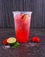 Refreshing Raspberry Mojitos made with lime juice, mint leaves, and sparkling water served in glass isolated dark background side view of healthy drink photo