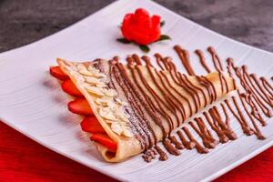 Decadent Chocolate Strawberry Crepe served in plate isolated on table side view of indulgent dessert photo