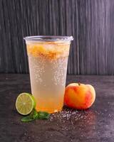 Refreshing Peach Mojitos made with peaches, lime juice, mint leaves, and sparkling water served in glass isolated dark background side view of healthy drink photo