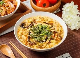 Hot and Sour Soup with Egg and Vegetables in bowl isolated on napkin side view on table taiwan food photo
