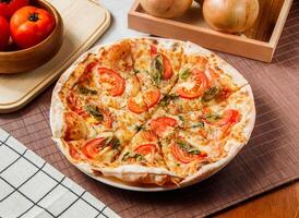 Classic Margherita Pizza topping with tomato and basil leaf served in plate isolated on table side view of taiwan fast food photo