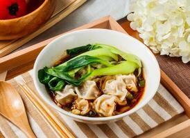 Spicy Szechuan Wonton Soup in bowl served in wooden tray side view of taiwan food photo