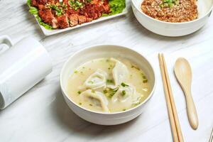 Handmade Soup Dumplings with pork chop, minced pork rice, served in dish isolated on marble background side view of taiwan food photo